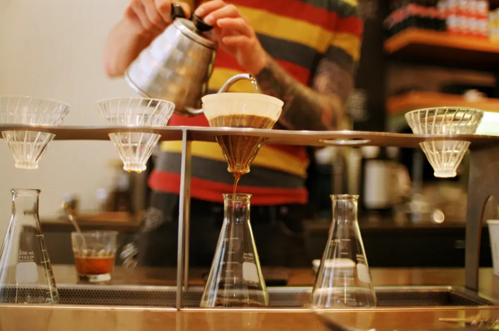 Barista valab kuuma vett käsitsi kohvifiltritesse kohvikuletil