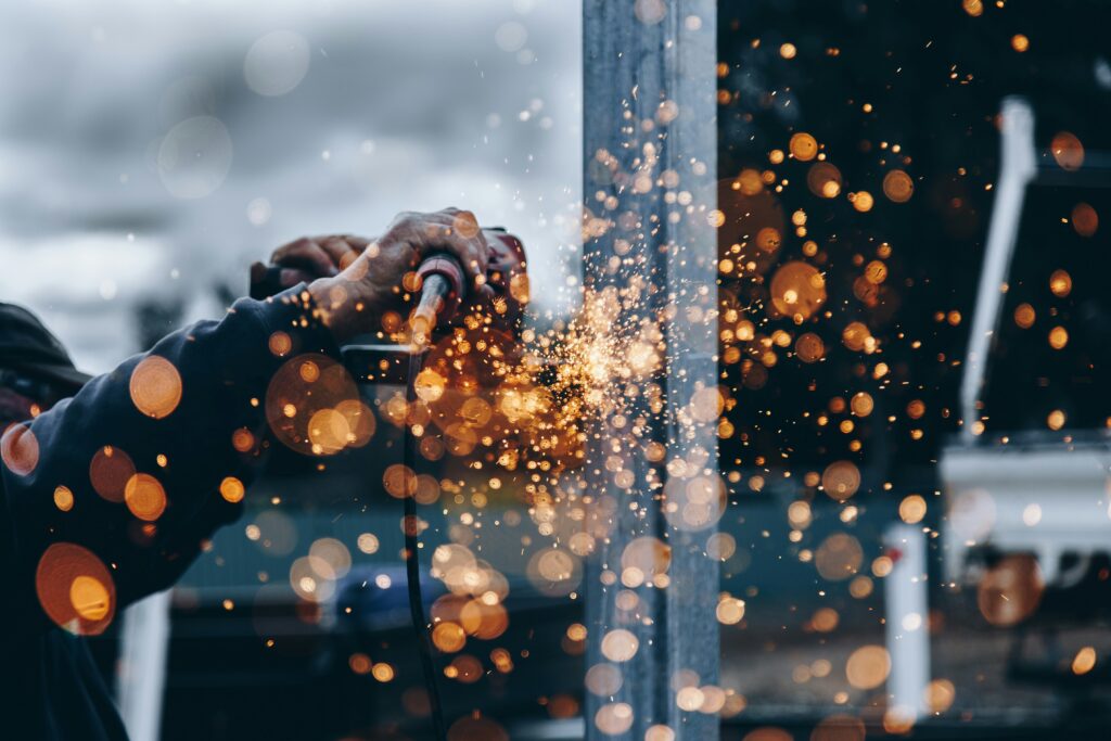 Keevitaja töötab metallkonstruktsiooni juures, sädemed lendavad