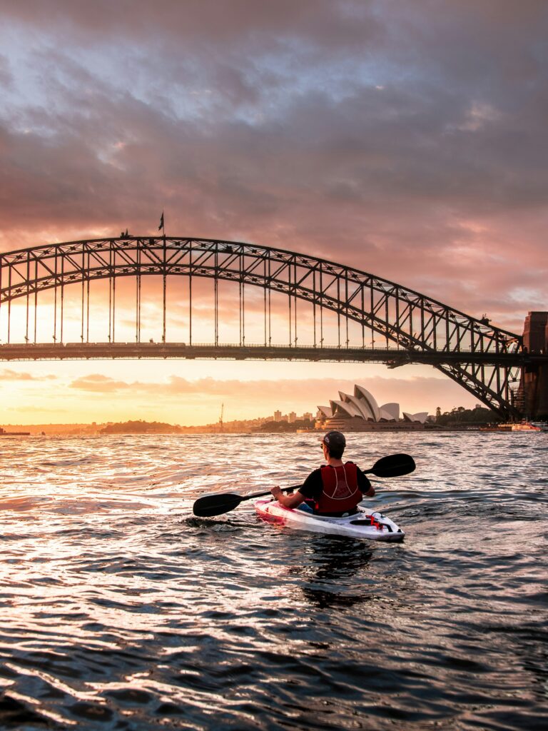 Kajakisõitja Sydney sadamas sadamasilla ja ooperimaja taustal koidikul